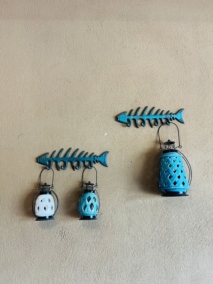 Creative wall art featuring lanterns and fish bone decor in a minimalist style.