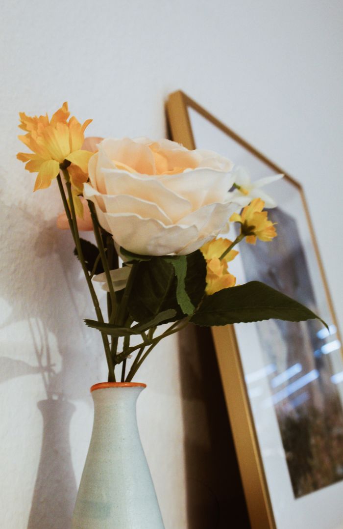 Chic floral arrangement with yellow and white flowers in a modern vase, perfect for home decor.